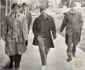 Negro resumes classes. Hamilton Holmes, a Negro student, is escorted to his first class by university officials at the University of Georgia in Athens today following a court order for readmission. Demonstrations forced his withdrawal last week