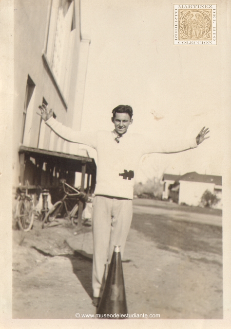 A male cheerleader wearing his letter sweatshirt "M" with a bull horn at his feet