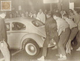 Princeton University students hoist a car and its occupants from street to sidewalk during spring fever uprising described as the most devastating since 1957. Some 1,500 participated in the riot and 12 undergraduates were arrested